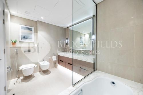 een badkamer met toilet en glazen douche bij Bloomfields Executive 3BR Apt Fujairah Address in Fujairah
