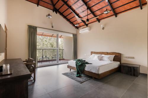 een slaapkamer met een bed en een balkon bij Samarya Chikkamagaluru in Chikmagalūr