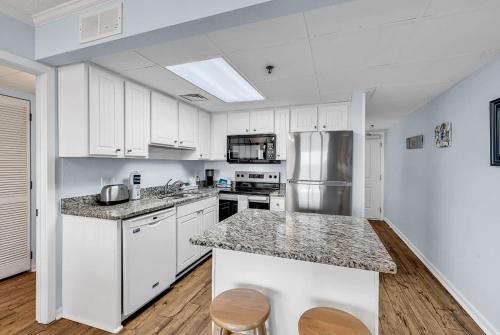 a kitchen with white cabinets and a counter top at Oceanfront Luxury 2BR Litchfield Beach Escape in Pawleys Island