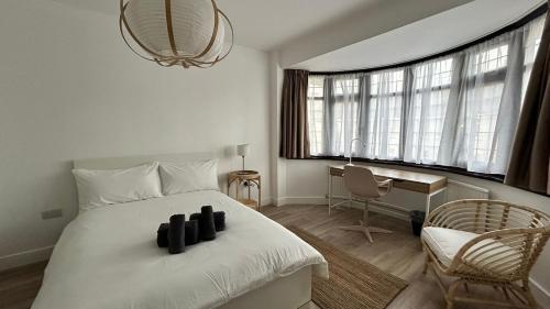 a bedroom with a large white bed and a desk at Family Ensuite Room for 3,Piccadilly Line,Work Desk & Easy Tube Access 4 in London