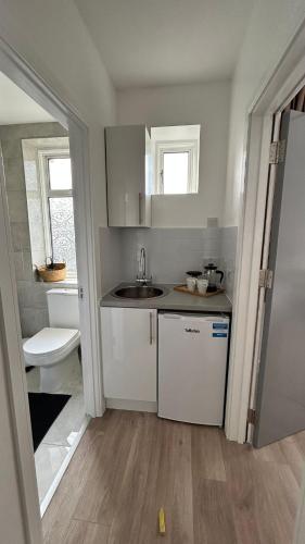 a small kitchen with a sink and a toilet at Family Ensuite Room for 3,Piccadilly Line,Work Desk & Easy Tube Access 4 in London