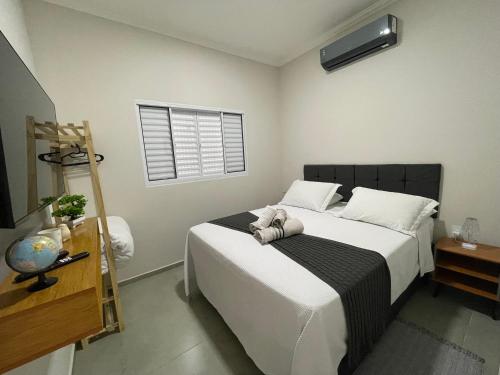 une chambre avec un grand lit et une fenêtre dans l'établissement Casa Lago da Dinda 3, à Espirito Santo Do Pinhal