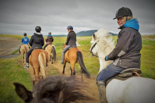 a group of people riding horses down a dirt road at Saltvík Farm Guesthouse in Húsavík