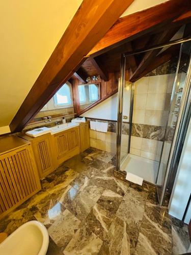 an attic bathroom with a shower and a toilet at Residence Villa Greta in Meina