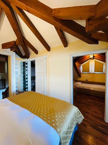 a bedroom with a bed in a room with wooden ceilings at Residence Villa Greta in Meina