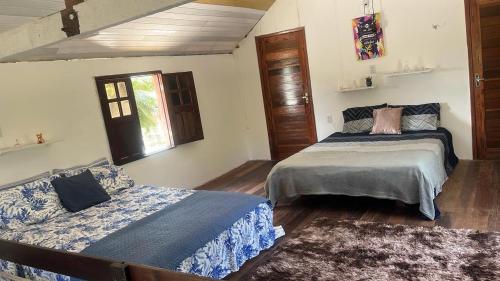 a bedroom with two beds and a window at Chalé Gran Paraíso Cotijuba in Belém