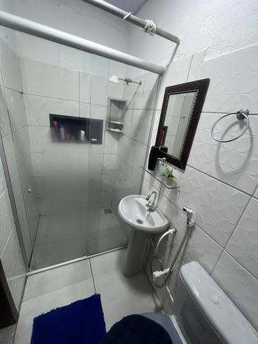 a bathroom with a shower and a sink and a mirror at Chalé Gran Paraíso Cotijuba in Belém