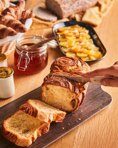 Campanile Lille - Lomme في لوم: شخص يقطع رغيف خبز على لوح تقطيع