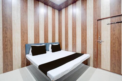 una camera da letto con un letto con una parete in legno di SPOT ON The Yeble Hotel And Restaurant a Etāwah