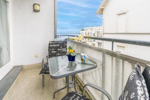 ein Balkon mit einem Glastisch und Stühlen darauf in der Unterkunft Ferienwohnungen Regina Maris in Bansin