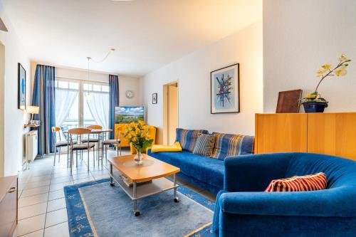 ein Wohnzimmer mit einem blauen Sofa und einem Tisch in der Unterkunft Ferienwohnungen Regina Maris in Bansin