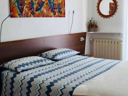 een slaapkamer met een bed met een kussen en een schilderij bij Affittacamere Lively in Novara