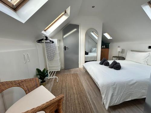a bedroom with two beds and a table and a room at Bright Loft Ensuite Room,Piccadilly Line,Unique Top-Floor Stay 5 in London