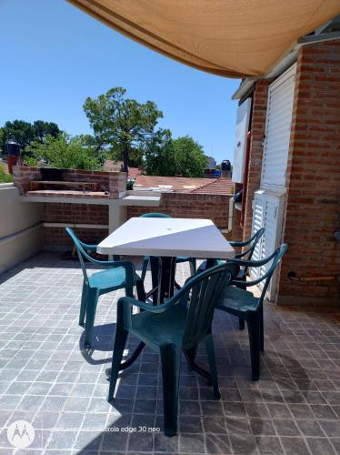 een tafel en stoelen op een terras bij Amanece en la playa 2 in Santa Teresita