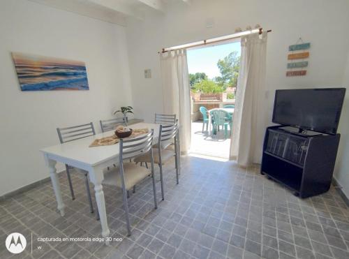 een woonkamer met een tafel en een televisie en een tafel en stoelen bij Amanece en la playa 2 in Santa Teresita