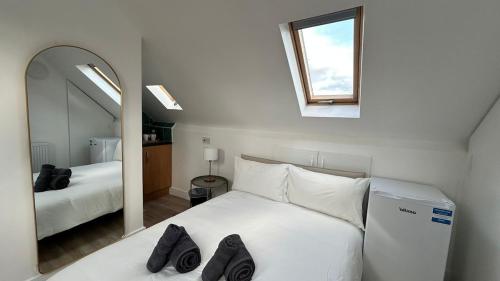 a bedroom with a white bed and a mirror at Bright Loft Ensuite Room,Piccadilly Line,Unique Top-Floor Stay 5 in London