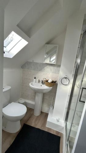 a white bathroom with a toilet and a sink at Bright Loft Ensuite Room,Piccadilly Line,Unique Top-Floor Stay 5 in London