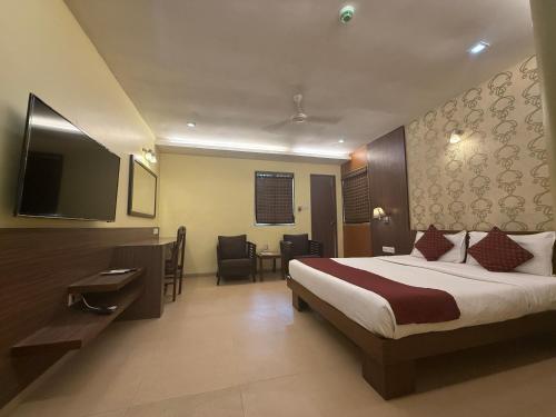 a hotel room with a bed and a flat screen tv at Hotel Beach Garden in Mumbai