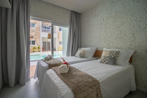 a bedroom with two beds and a large window at Apartamentos Curimã in Passo de Camarajibe