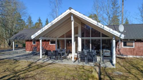 een paviljoen met stoelen en tafels op een patio bij Villavilla #244 - Öland, Sverige in Grönskog