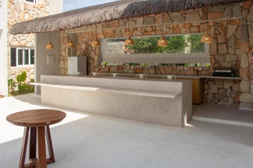 a restaurant with a counter and a table and a stool at Apartamentos Curimã in Passo de Camarajibe