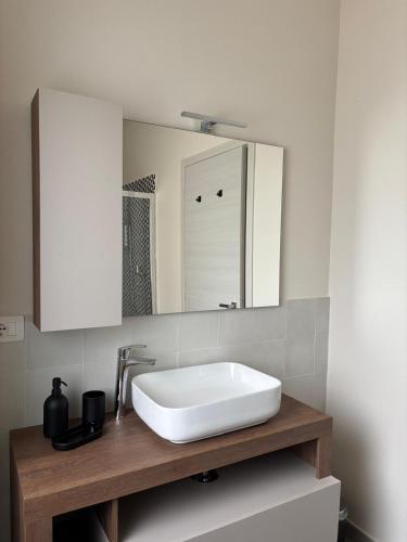 ein Badezimmer mit einem weißen Waschbecken und einem Spiegel in der Unterkunft villa Pieri appartamento black in Fauglia