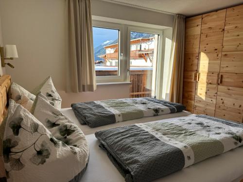 two beds sitting in a room with a window at Appartement Wilhelm in Ehrwald