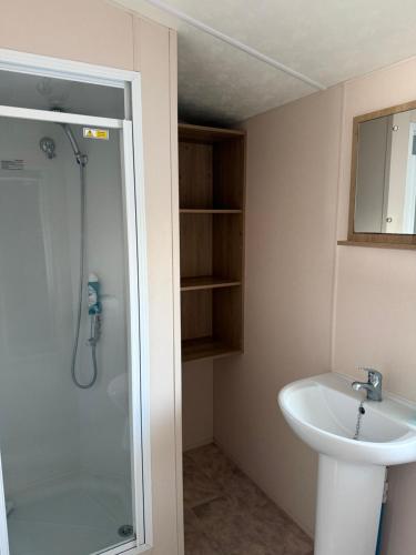 a bathroom with a shower and a sink at Coastal Beachfront Caravan in Brightlingsea