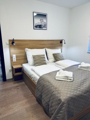 a bedroom with a large bed with a wooden headboard at Nourt II in Karpacz