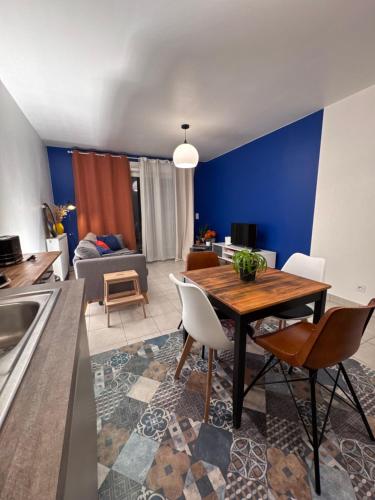 eine Küche und ein Wohnzimmer mit einem Holztisch und Stühlen in der Unterkunft Small 2 room cocoon in a luxury building in Lognes