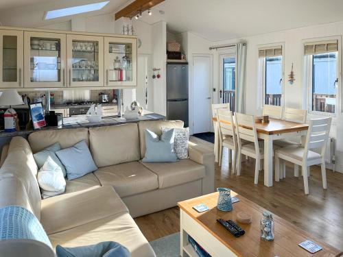 a living room and kitchen with a couch and a table at 19 Salcombe Retreat in Salcombe