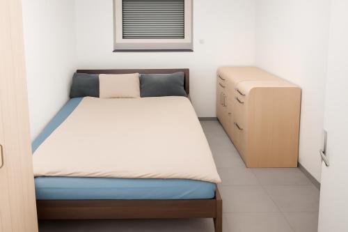 een kleine slaapkamer met een bed en een dressoir bij Hotelikum in Heilbronn