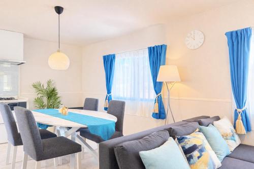 a living room with a couch and a table at Sunstone Residence 2F - Free Rental Car & Airport Pickup - 10 Min to American Village in Ginowan