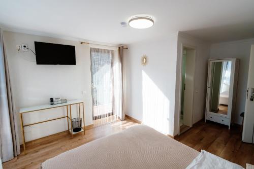 a bedroom with a bed and a television on the wall at Oana's Boutique in Bran