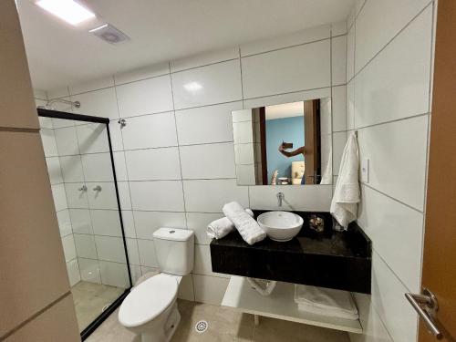 une salle de bains avec toilettes, lavabo et miroir dans l'établissement Max Carneiros Suítes - Com e sem piscina privativa, à Praia dos Carneiros