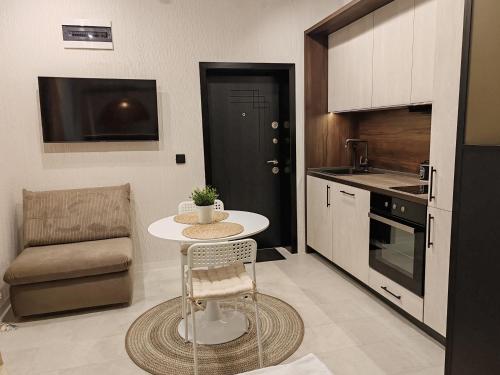 een kleine keuken met een tafel en een stoel bij SOHO apartments in Boergas