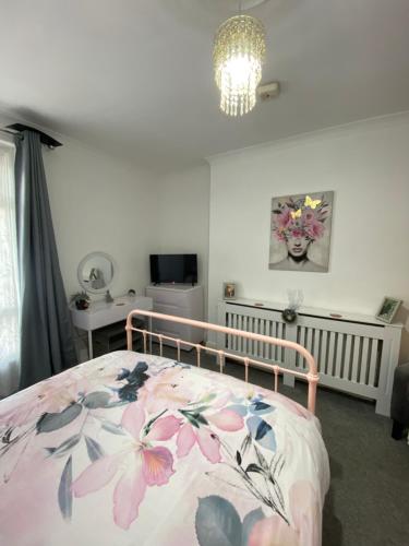 - une chambre avec un lit et une couverture fleurie dans l'établissement Chic & Cosy Studio Apartment, à Southampton
