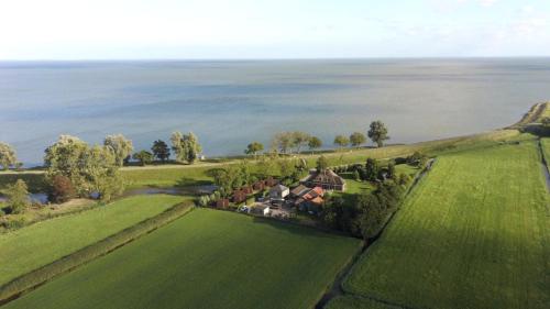 an aerial view of a house on a green field at Hotelhuisjes Oosterleek in Oosterleek