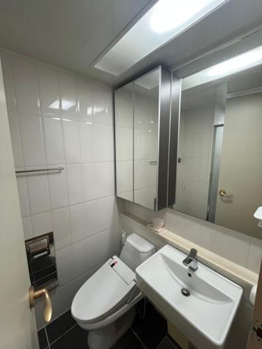 a bathroom with a white toilet and a sink at 부천역300m 코지하우스 in Sosa