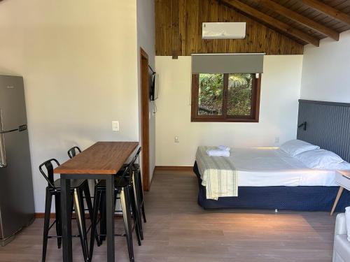 een kamer met een bed, een bureau en een tafel bij Pousada Jardim Da Lagoa in Florianópolis