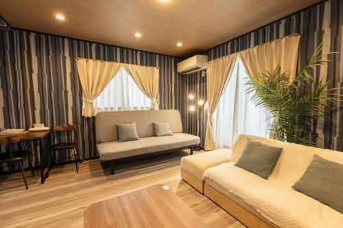 a living room with a couch and a table at 貸切新築ヴィラ l 最大9名 l 小田原城徒歩14分 l 無料P l 箱根板橋駅徒歩9分 l SENU VILLA Minamicho - Odawara in Odawara