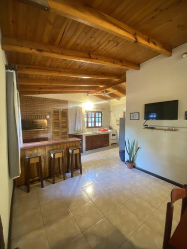 a large kitchen with wooden ceilings and a table at Cabaña Conectar Naturaleza in Ituzaingó