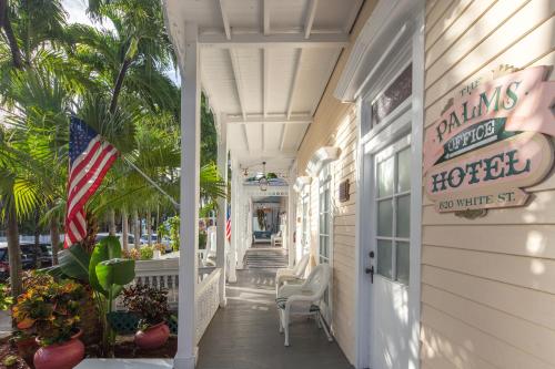 a front porch of a hotel with an american flag at The Palms Hotel in Key West