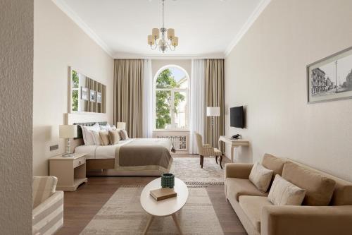 a bedroom with a bed and a living room with a couch at Boutique 19 Hotel in Baku