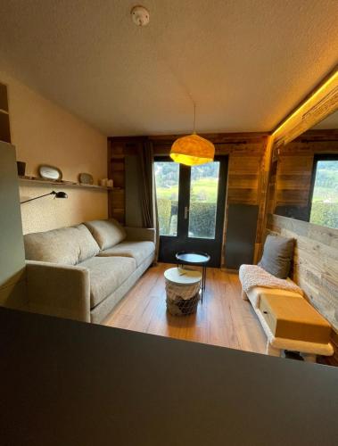 a living room with a couch and a table at Charming studio with terrace and garden in Praz-sur-Arly