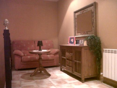 a living room with a couch and a mirror at Hotel Restaurante el Fornon in Novellana