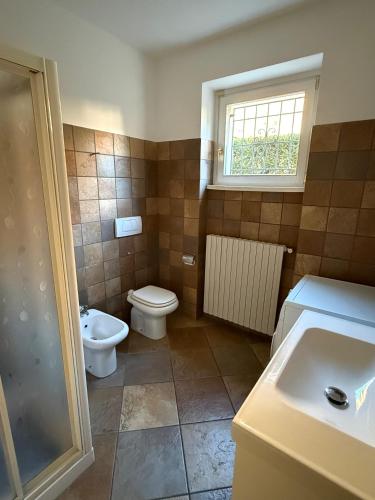 a bathroom with a toilet and a sink and a window at Dimora degli Gnomi in Tirano