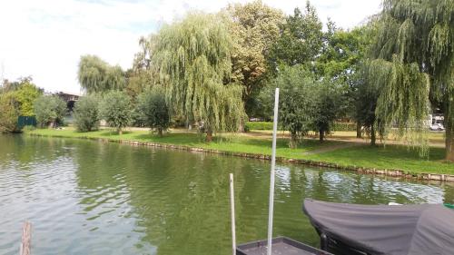 a boat is docked on a river with trees at Lake Park in Berlare