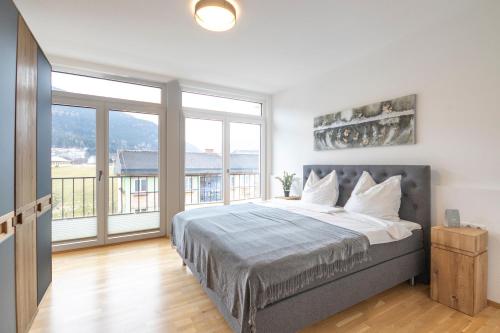 Un dormitorio con una cama grande y un balcón. en Murleben Appartements, en Stadl an der Mur