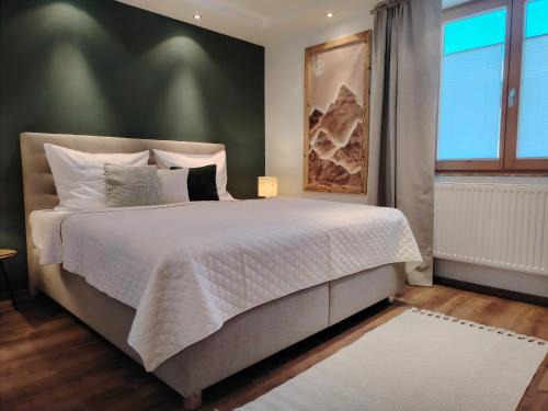 a bedroom with a large white bed and a window at Goldberg-Aparts in Rauris